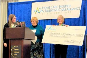 Lisa Whitney (holding check) is awarded the 2025 Caregiver Superstar Award from the Phaneuf Family Foundation.